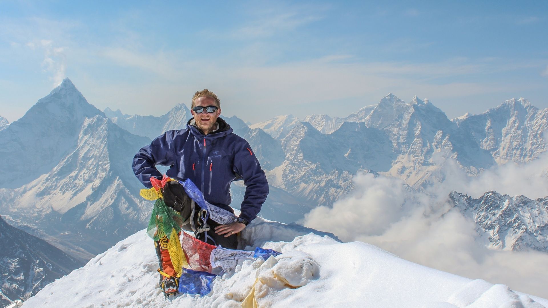 Man on the summit of a snow topped mountain