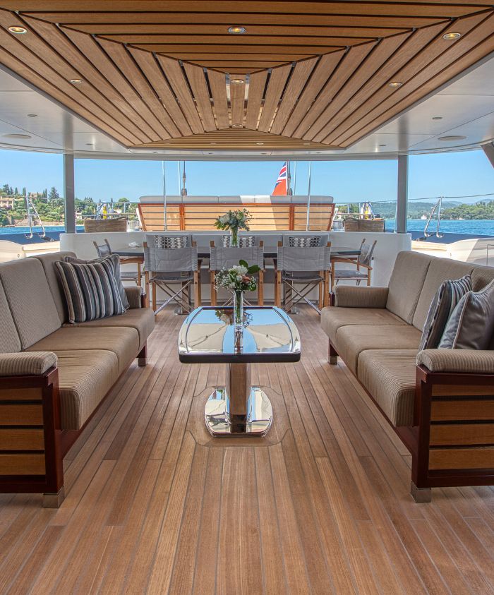 Back aftdeck of large luxury sailing boat with bar, table, dining area and sofas