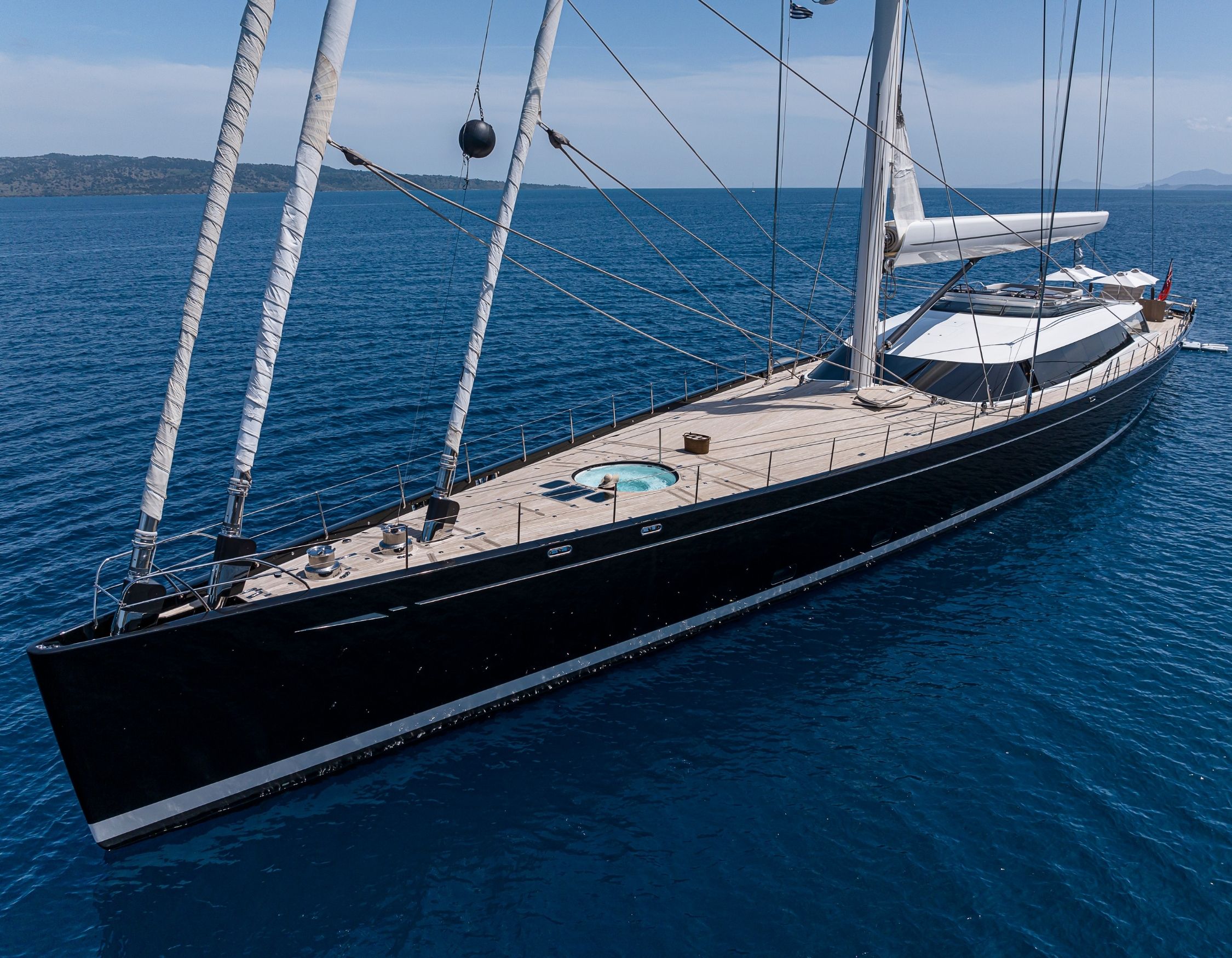 Luxury sailing yacht in clear blue waters with masts and Jacuzzi