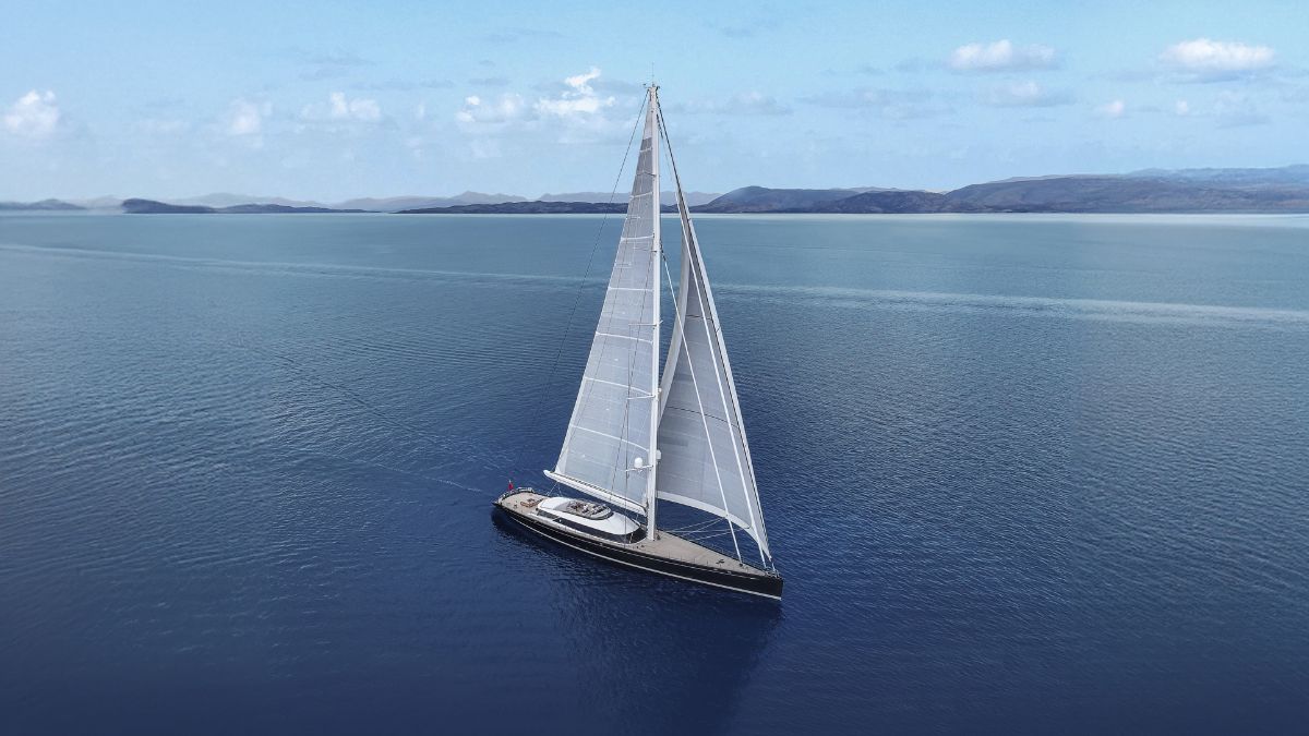 Luxury sailing yacht in clear blue waters with large white sails and Jacuzzi