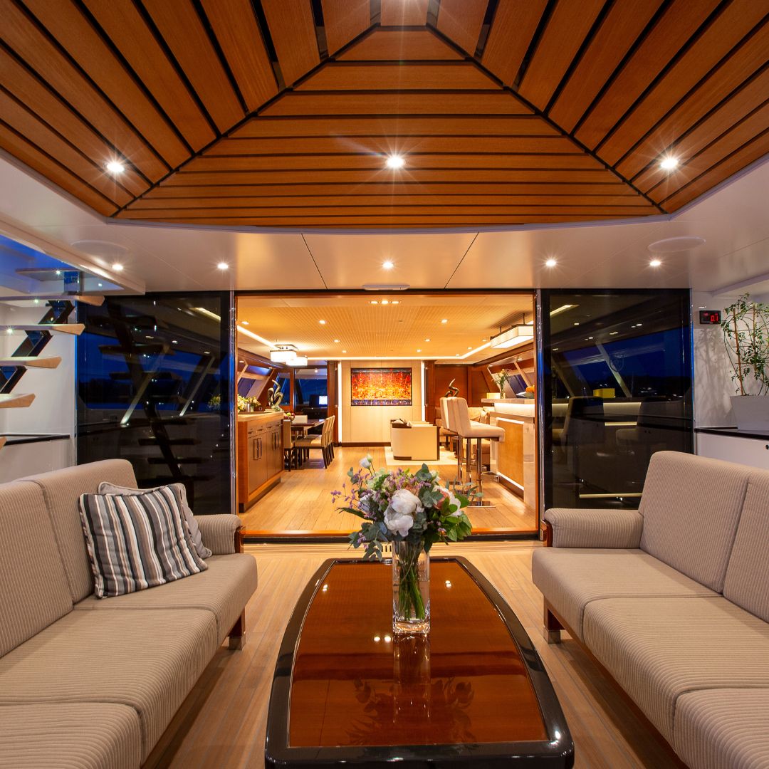 Aftdeck of large luxury sailing yacht with sofas, bar and outdoor al fresco dining area