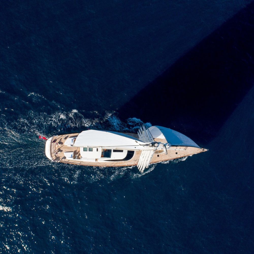 Aerial view of luxury sailing yacht cruising clear blue Mediterranean waters – Pelorus Yachting 2026 cinematic Odyssey voyage.