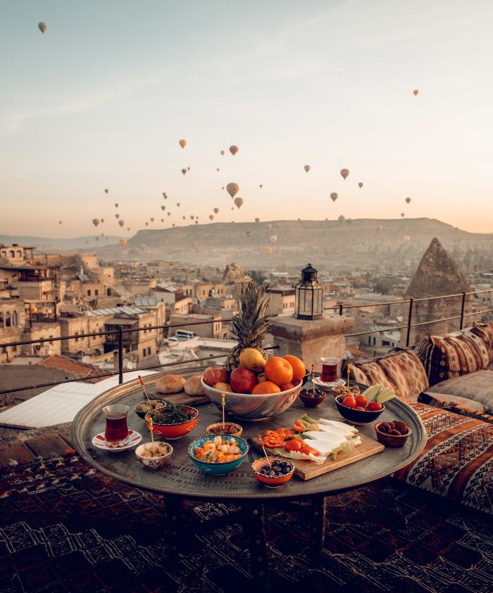 Mezze table overlooking Troy, Turkey at sunset with hot air balloons – Pelorus Yachting 2026 luxury yacht charter Odyssey voyage.