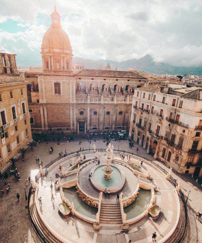 Historic square with ancient stone buildings and fountain – Pelorus Yachting 2026 Mediterranean luxury yacht charter Odyssey journey.