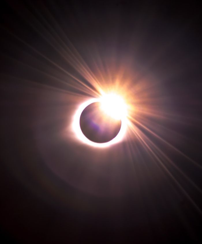 Solar eclipse over Greenland skies creating a dramatic celestial circle – Pelorus Yachting 2026 luxury Arctic sailing experience.