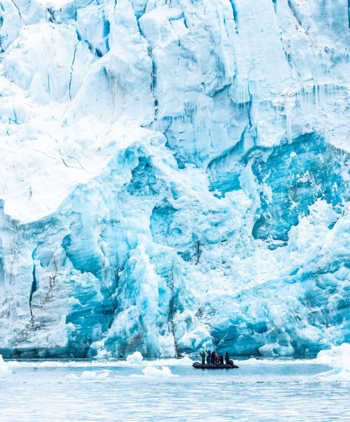 Tender navigating icy Greenland waters with towering ice formations – Pelorus Yachting 2026 luxury Arctic yacht adventure.