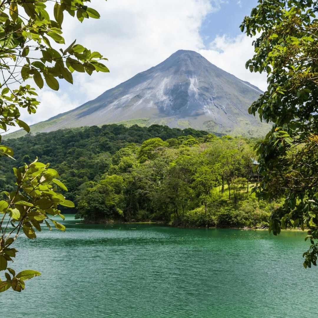 Volcano in background of Costa Rica with trees and river